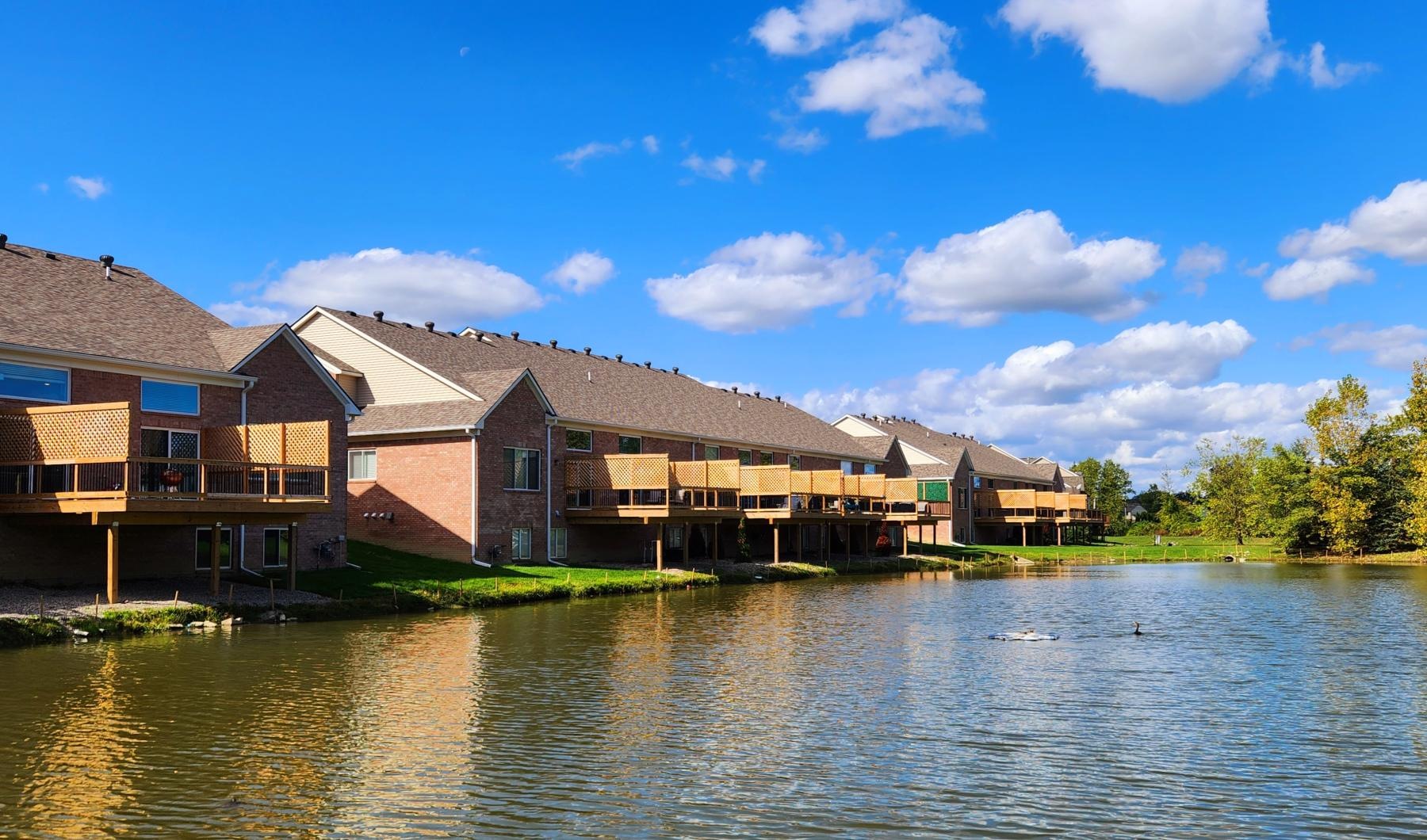 Settle into comfort at Briggs Park of Troy a row of houses on a river
